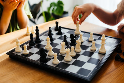 Low section of person playing on chess board