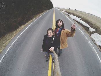 Portrait of a young woman standing on road