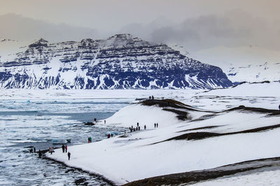 Scenic view of sea and snowcapped mountain against sky