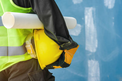 Midsection of man standing against yellow water