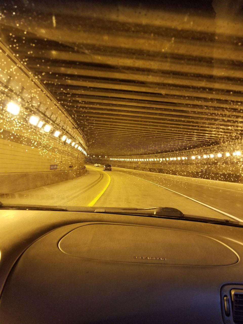 CARS ON ILLUMINATED ROAD SEEN THROUGH WINDSHIELD