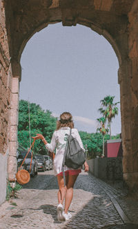 Rear view of woman walking on footpath