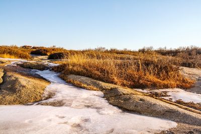 Scenic view of snow covered land against clear sky