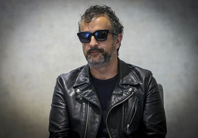 Portrait of man wearing sunglasses against wall