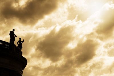 Low angle view of silhouette statue against sky