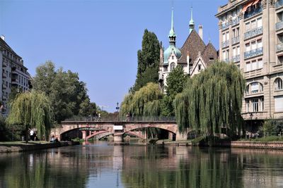 Bridge over river against buildings in city