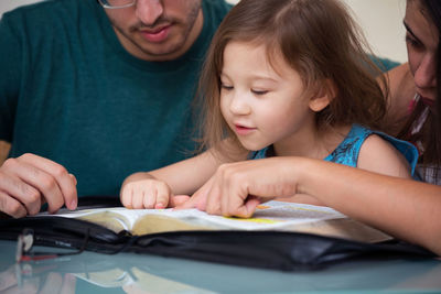 Portrait of a smiling young woman reading book