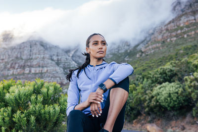 Portrait of young man standing against mountain