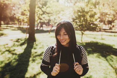 Portrait of smiling young woman standing outdoors