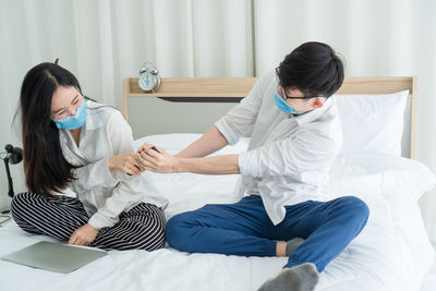 Rear view of couple sitting in corridor