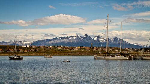 Sailboats moored in lake against sky