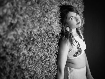 Portrait of woman standing against wall