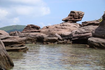 Rock formations in sea against sky