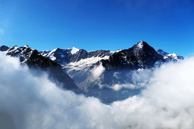 Scenic view of snowcapped mountains against blue sky