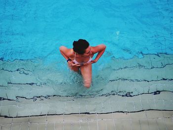 Rear view of shirtless woman in swimming pool