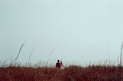 People on field against clear sky