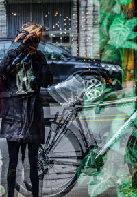 Reflection of man on bicycle in city