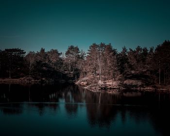 Scenic view of lake in forest against clear sky