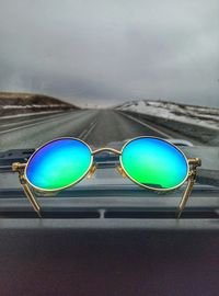Close-up of sunglasses against blue sky