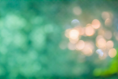 Defocused image of illuminated lights against sky at night