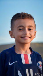 Portrait of boy smiling against blue sky