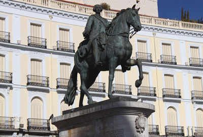 Low angle view of statue against building in city