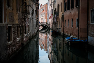 Bridge over canal amidst old buildings in city