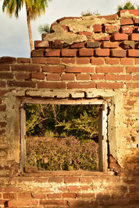 Old weathered wall by building against sky