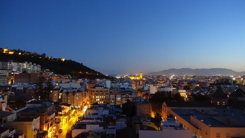 High angle shot of illuminated townscape against sky at dusk