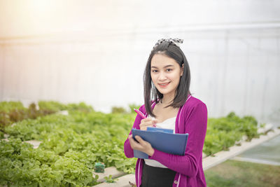 Portrait of a smiling young woman standing outdoors