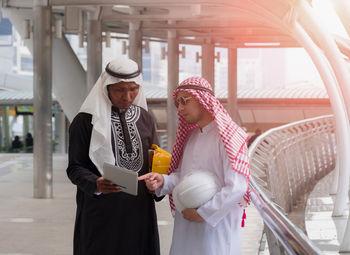 Low section of man and woman standing on mobile phone