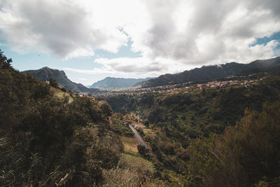 View of village in wooded mountainside in foggy. levada da agua de alto trail on madeira, portugal