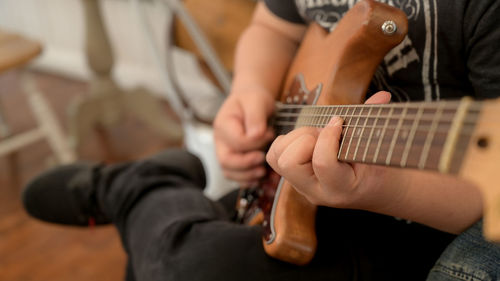 Low section of man playing guitar