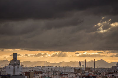 Buildings in city against cloudy sky