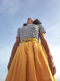 Low section of woman standing against sky