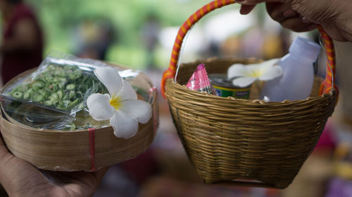 Close-up of cropped hands holding baskets with flowers