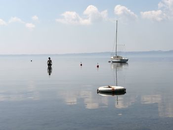 Shirtless boy in sea against sky