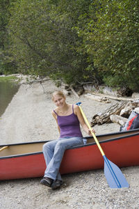 Portrait of woman sitting in boat on shore