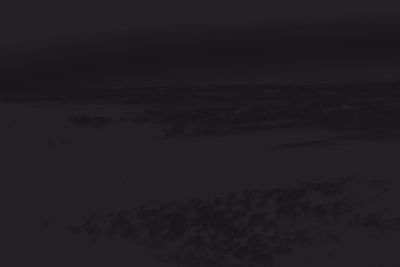 Silhouette landscape against sky at night