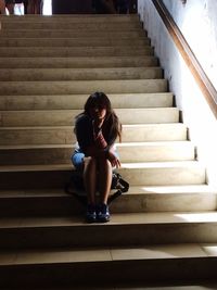 Young woman sitting on stairs