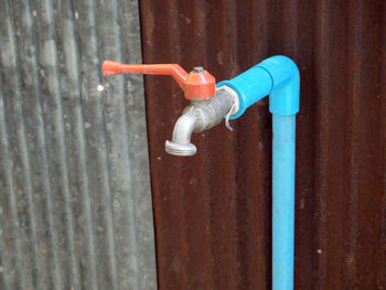 Close-up of faucet against blue door