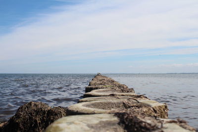 Scenic view of rocks on beach against sky