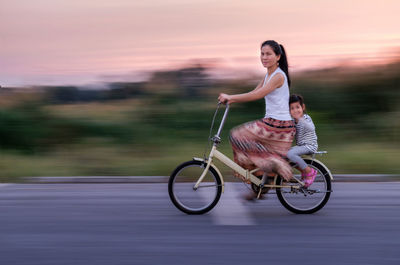 Blurred motion of woman and girl on bicycle