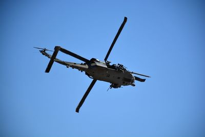 Low angle view of airplane against clear blue sky