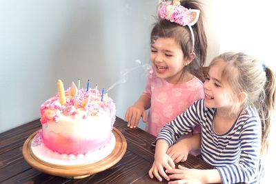 High angle view of girls looking at birthday cake