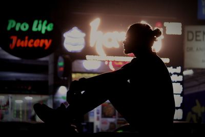 Silhouette man standing by illuminated text