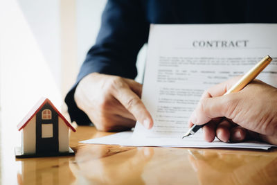 Midsection of man holding paper with text