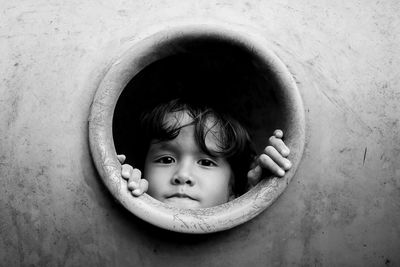 Close-up portrait of cute boy looking through circle at playground