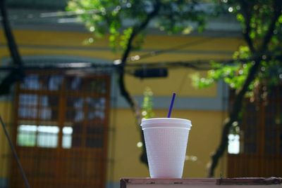 Disposable cup on table against house