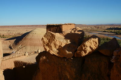 Rock formations on landscape against clear blue sky